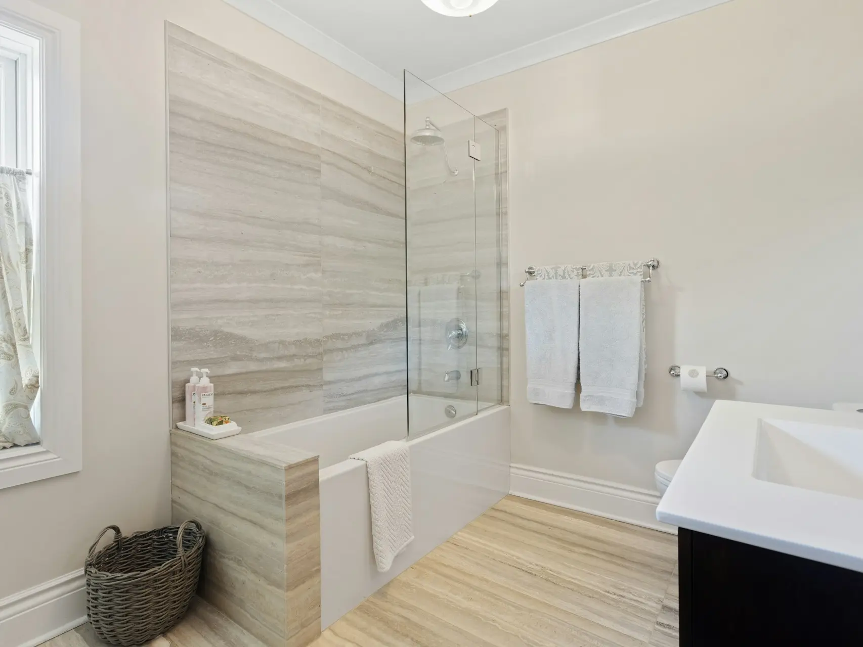 a bathroom with a tub, sink, and mirror